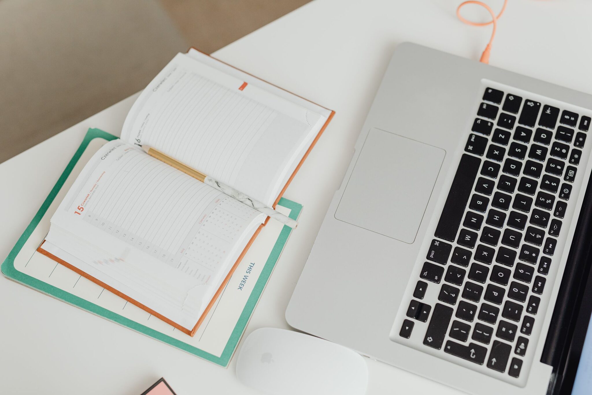 Executive VA planning a business owner's week on a laptop calendar and paper diary
